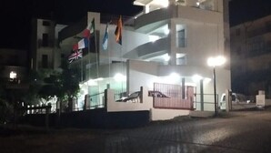 Un edificio a più piani con tetto piatto e ingresso chiuso da cancello.