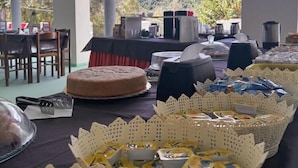 Un tavolo per buffet con diversi cibi e una torta, con sullo sfondo un paesaggio montuoso.