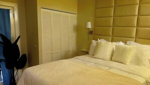 Un dormitorio con cama, armario y lámpara de noche.
