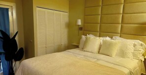 Un dormitorio con cama, armario y lámpara de noche.
