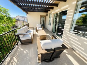 A balcony with outdoor furniture, a pergola, and a sliding glass door. - Desert Light Retreat | Lazy River & Splash Pad! (Hurricane)