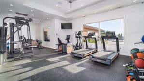 Una palestra con tapis roulant, macchinari ellittici e attrezzature per pesi.
