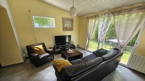 En stue med sofa, lænestol, fjernsyn og bord.