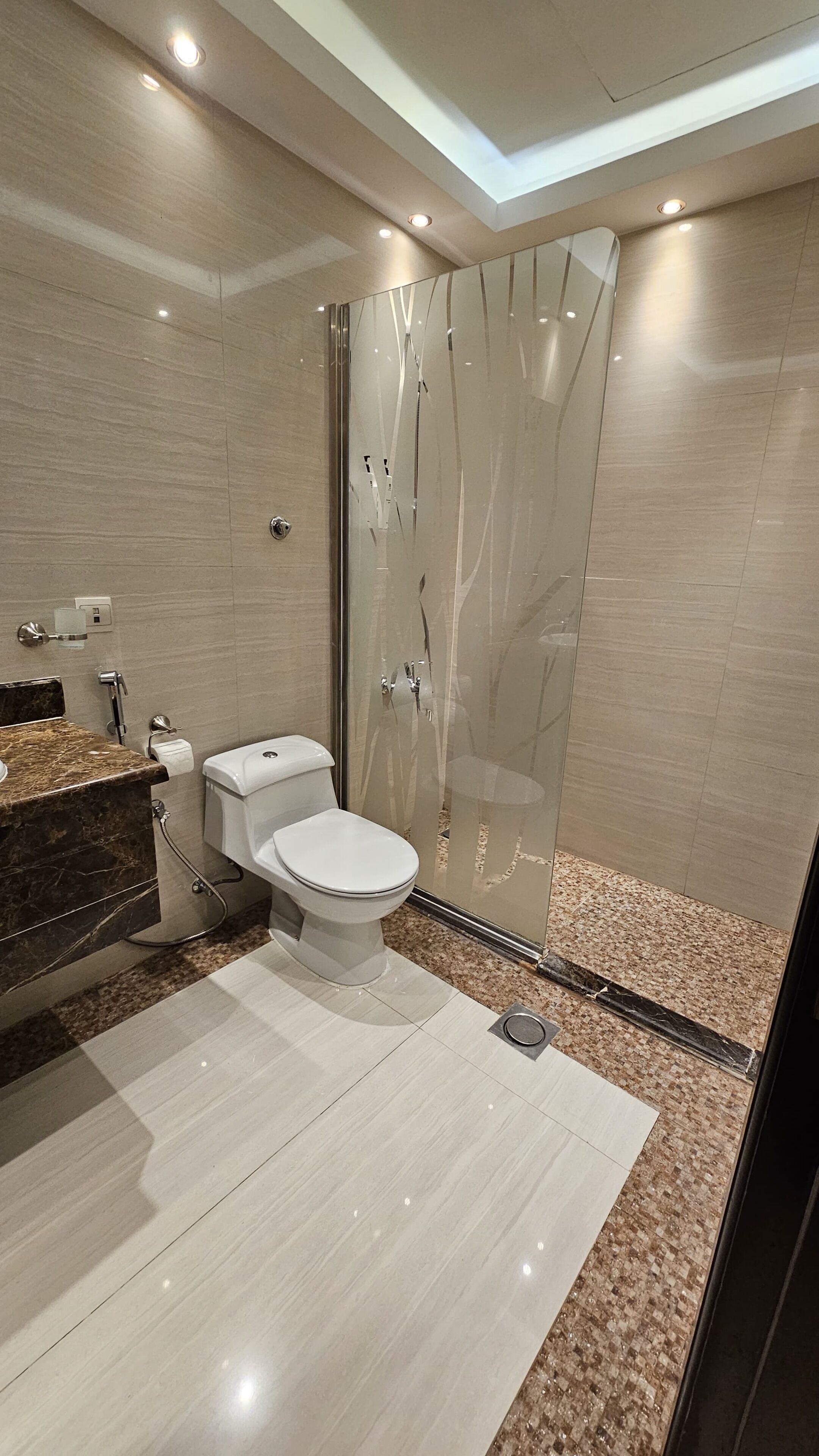 Un baño moderno con inodoro, lavamanos y zona de ducha.
