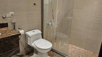 Un baño moderno con inodoro, lavamanos y zona de ducha.