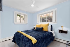A bedroom with a bed, two bedside tables, a ceiling fan, and two windows. - The Secret Garden at Benefit~

Tranquil, starlit views in PVD with Parking! (Providence)