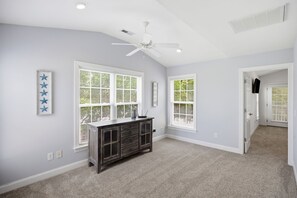 A room with two large windows, a ceiling fan, and a dark wooden cabinet. - Marina1: walk to marina, restaurants & more on ICW! (Southport)