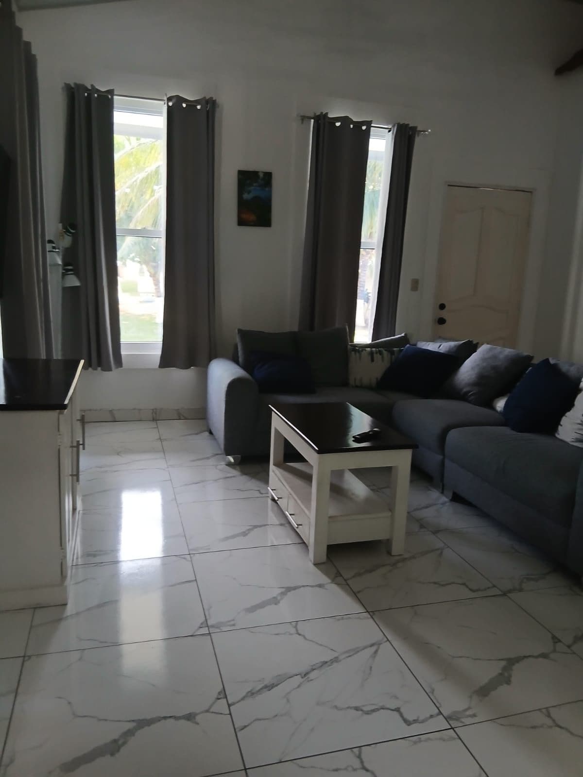 Una sala de estar con un sofá, una mesa de centro y una puerta.