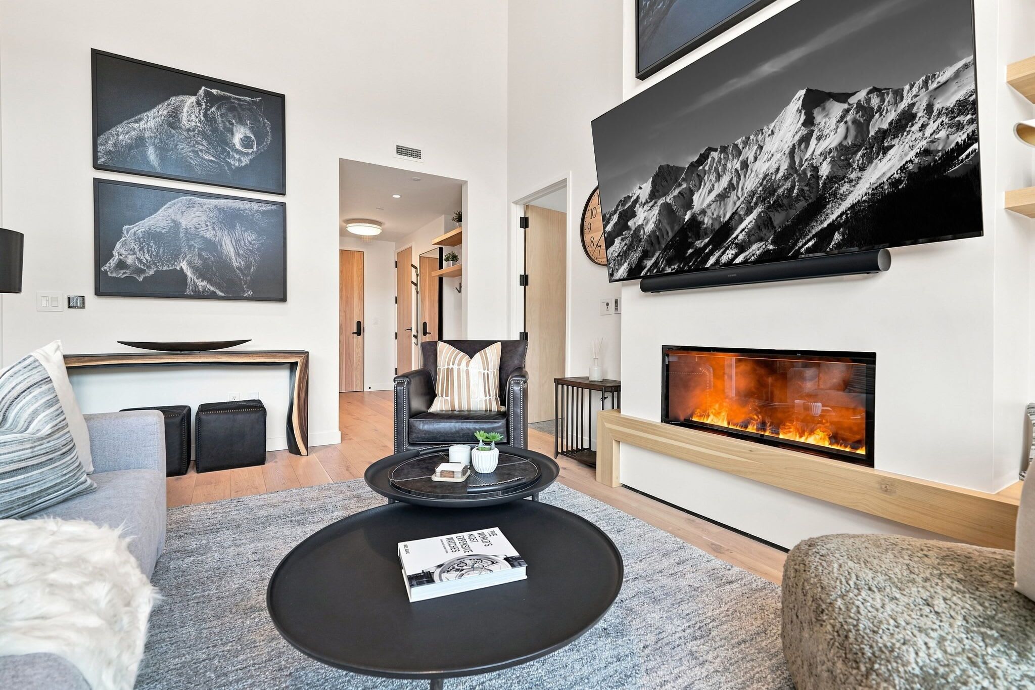 En moderne stue med pejs, sofa, sofabord og kunst på væggene.