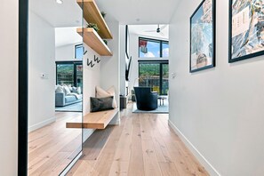 Ein modernes Interieur mit Holzboden, einer Bank, einem Sofa und einem Essbereich.