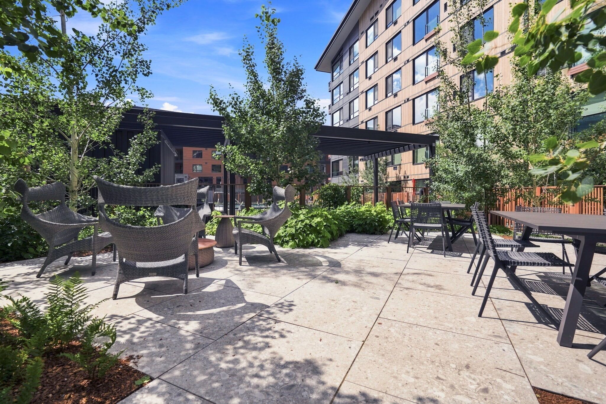 An outdoor patio area with seating arrangements and a building in the background.