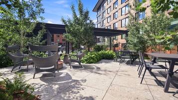 An outdoor patio area with seating arrangements and a building in the background.