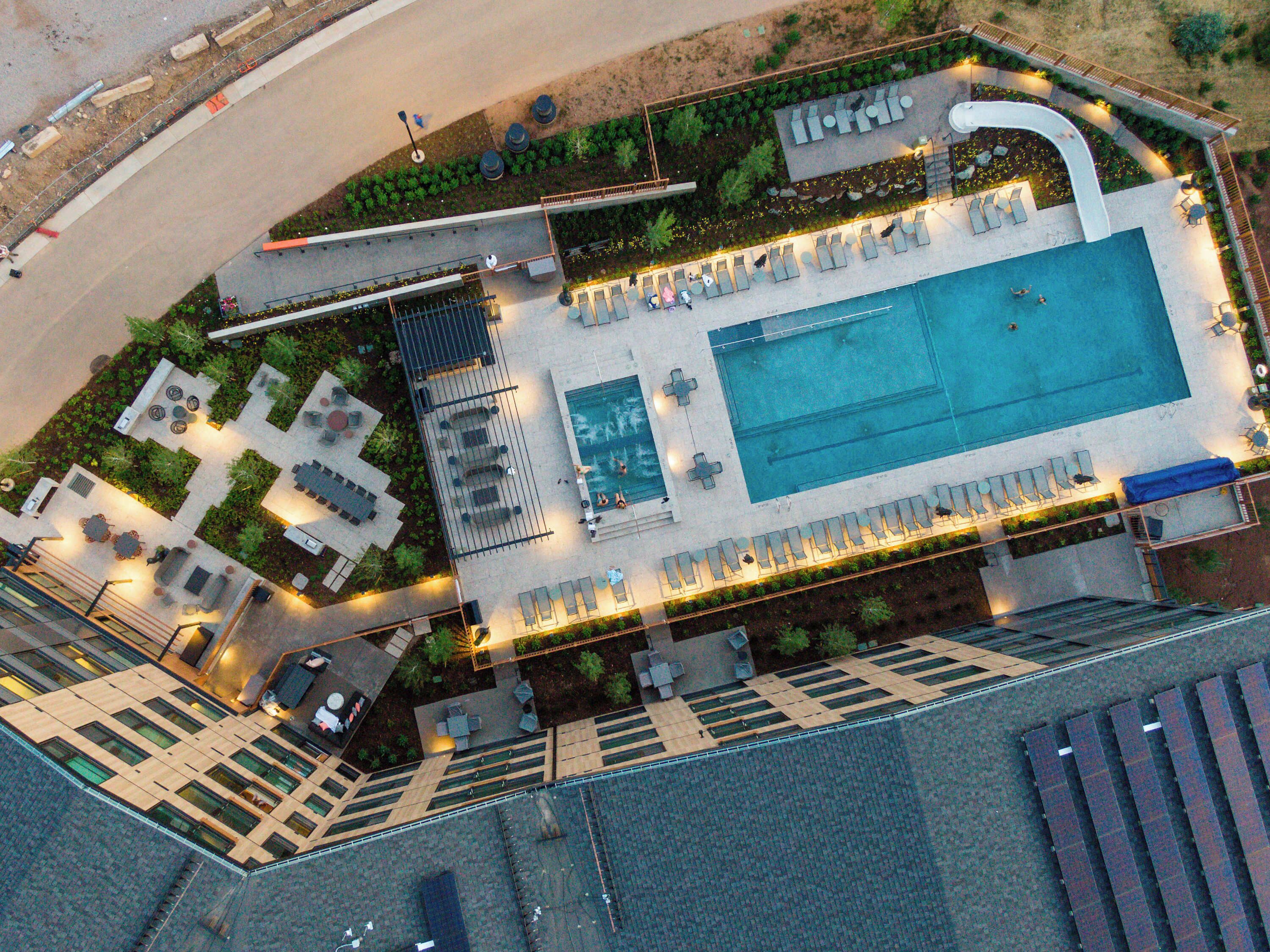 Vista aérea de un hotel con piscina, zonas de estar al aire libre y jardín ajardinado.