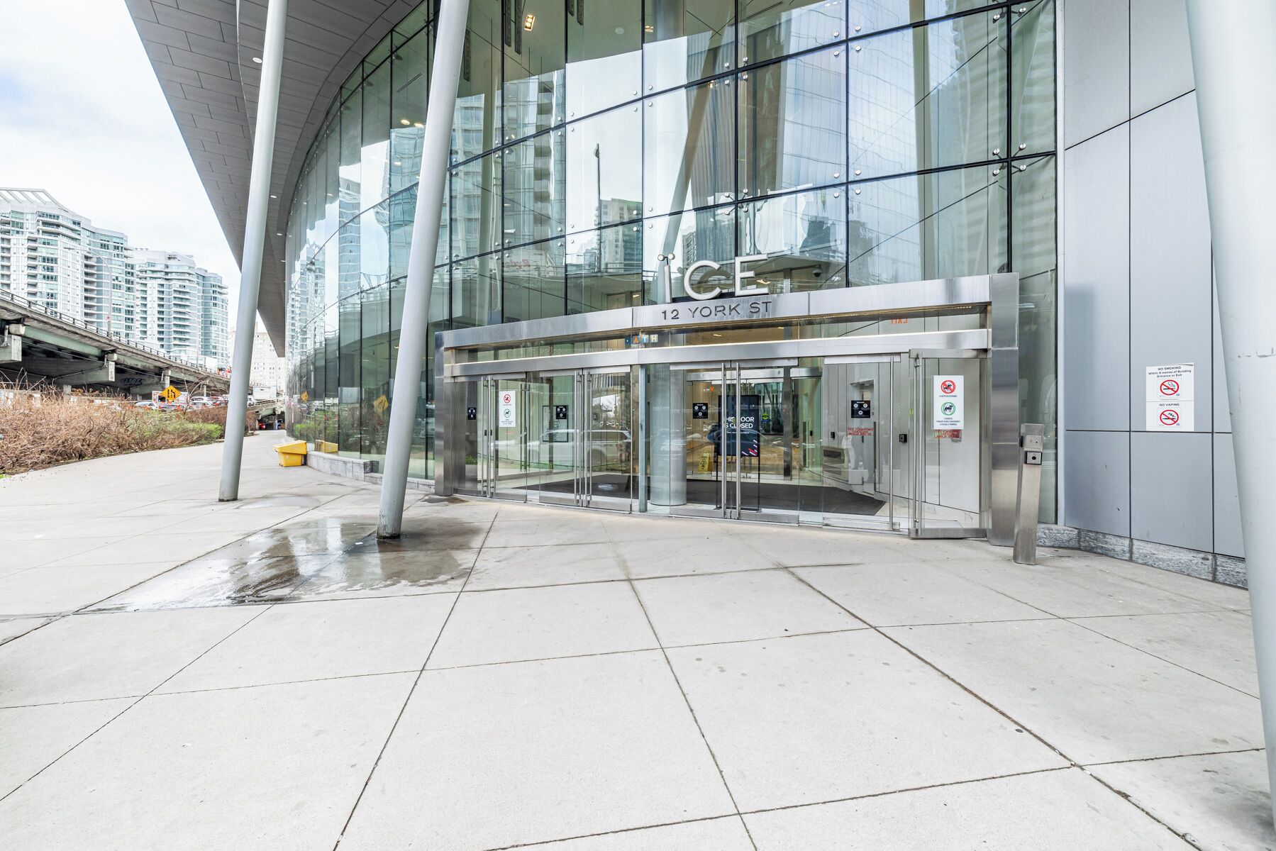 A modern building with a glass facade, a prominent entrance with a revolving door, and a sign indicating '12 York St.'