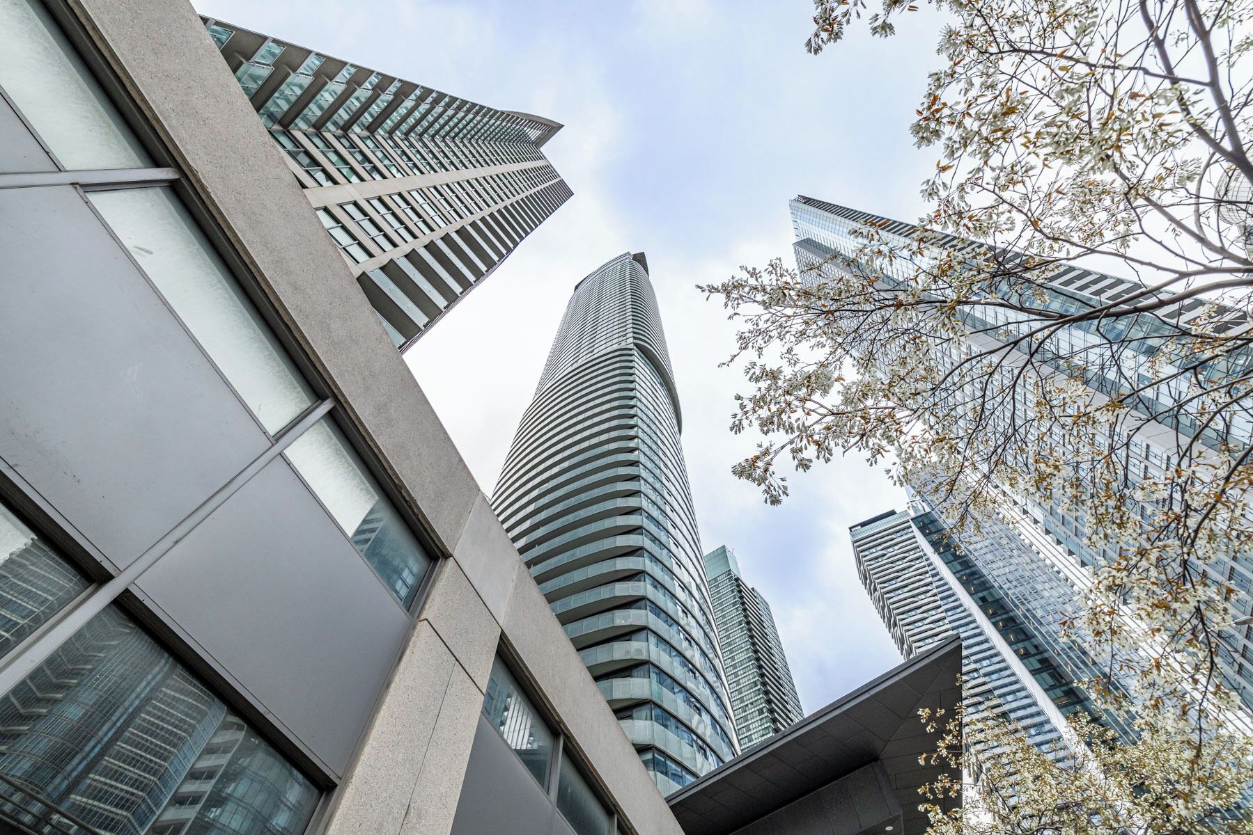 A modern high-rise building with a curved facade and reflective glass windows.