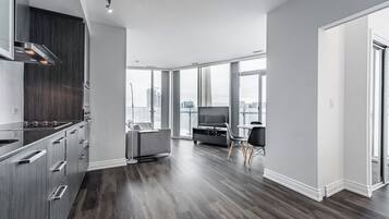 A modern apartment with a kitchen, living area, and large windows offering city views.
