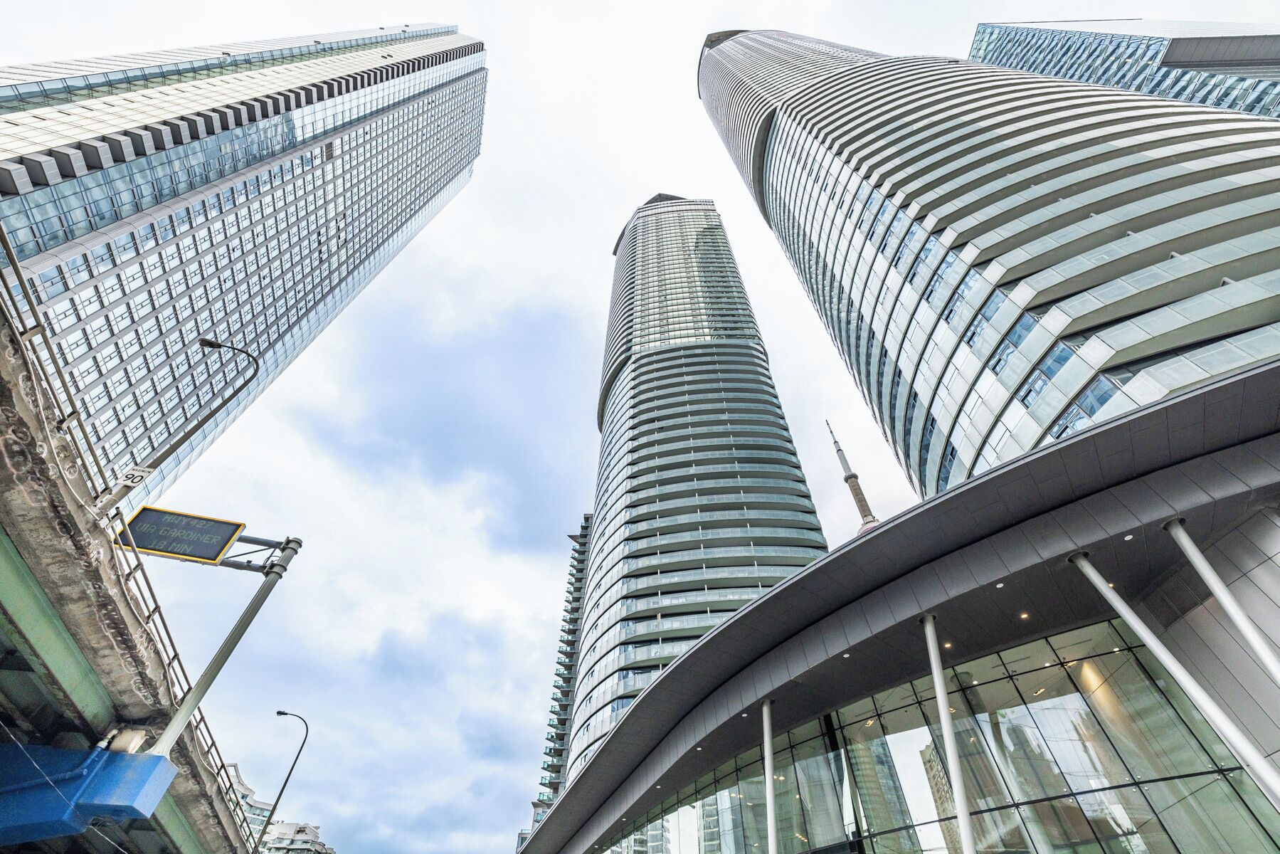 A modern high-rise building with a curved glass facade and a prominent central tower.