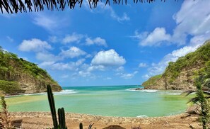 Un paisaje costero con cielo despejado, mar tranquilo y acantilados rocosos.