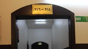 A hallway with a door marked 'Y17-Y10' and an 'EXIT' sign on the wall.