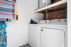 Ein Waschbereich mit Waschmaschine, gestreiftem Handtuch und Krücken.