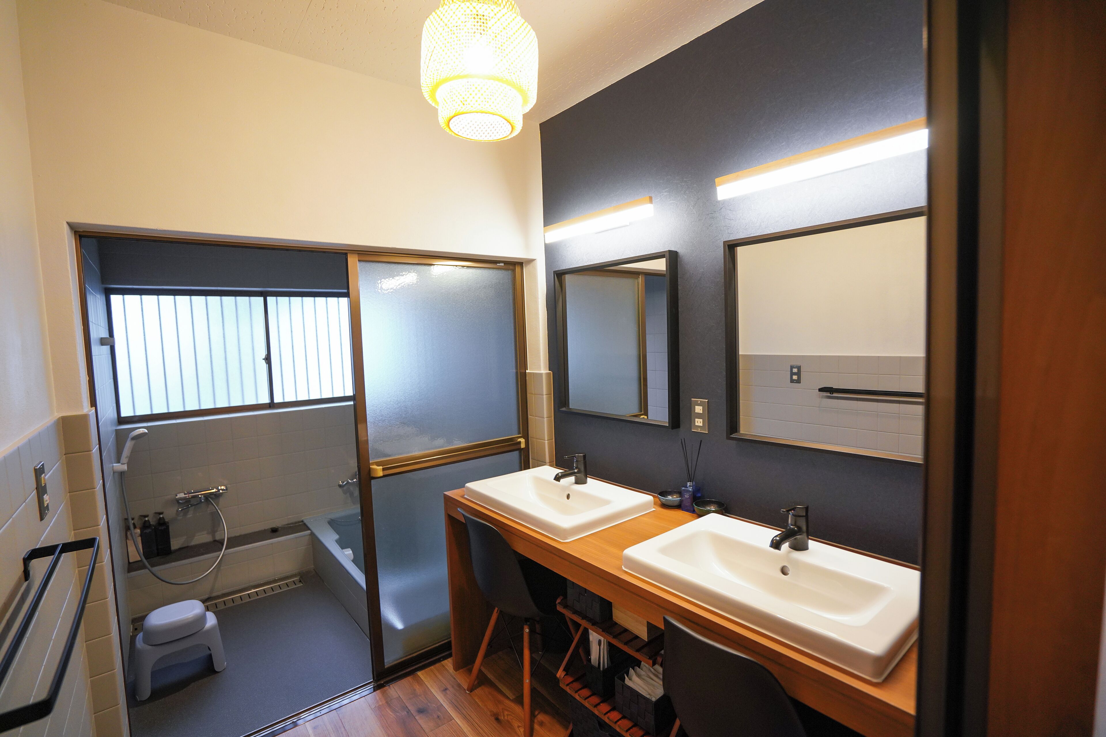 A modern bathroom with two sinks, a shower, and a toilet.