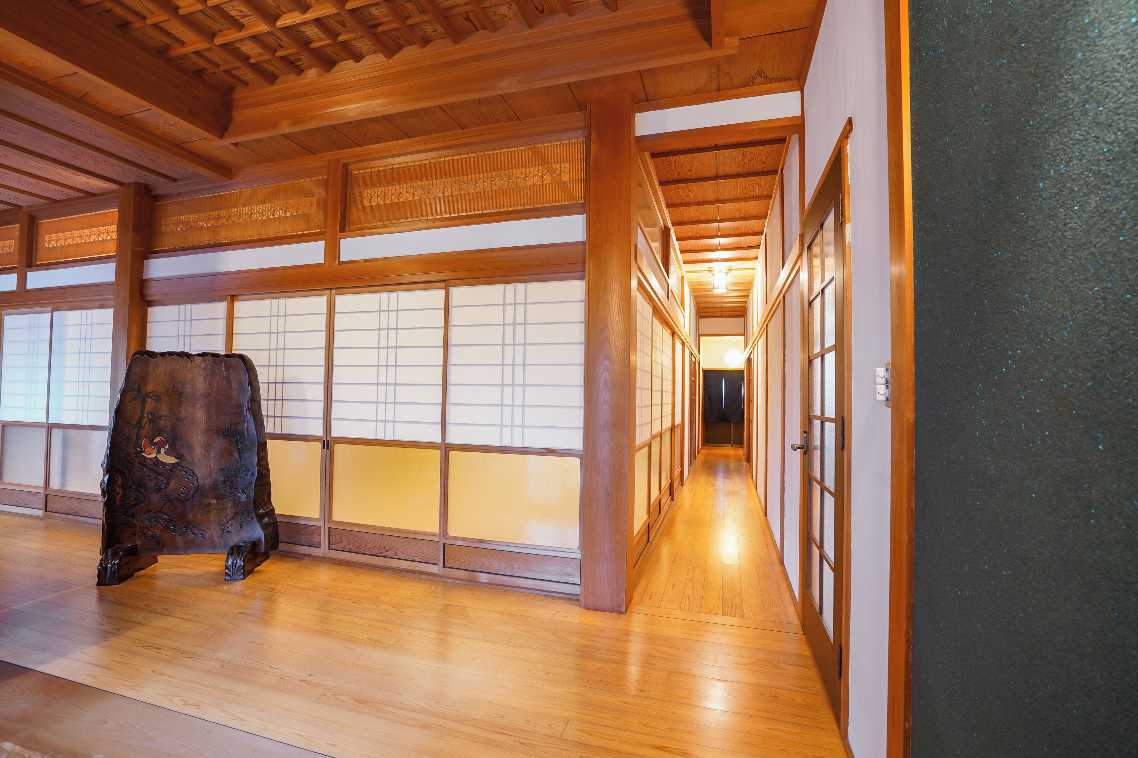 Un intérieur japonais traditionnel avec un plancher en bois, des portes coulissantes et un meuble en bois.