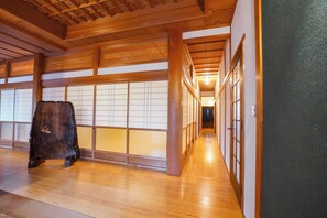 A traditional Japanese interior with wooden flooring, sliding doors, and a wooden cabinet.