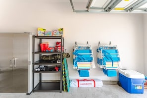 A garage with a storage unit, life jackets, and a cooler. - Low Rates WindMark| Golf Cart + Game Garage Retreat (Port St. Joe)