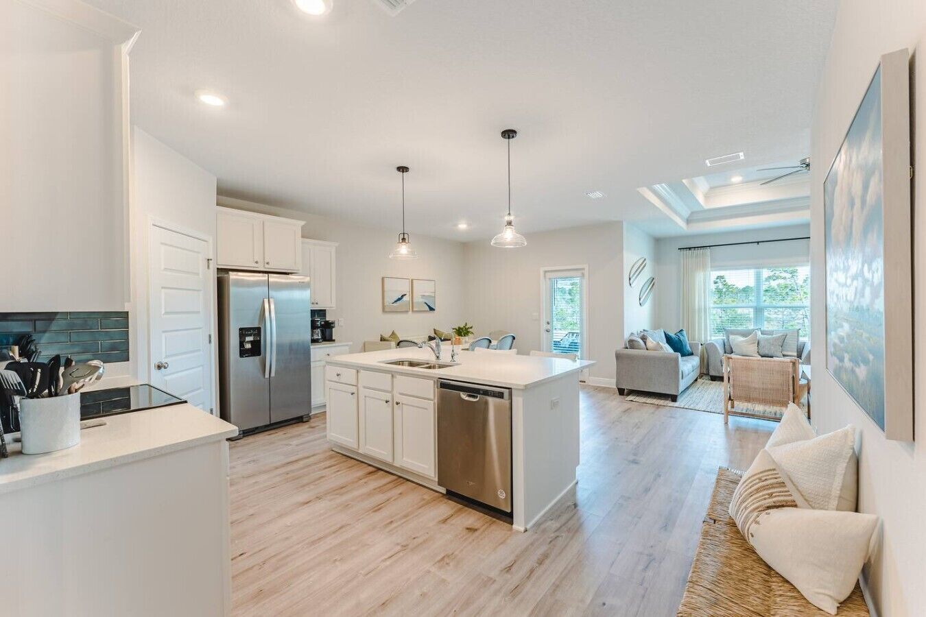 A modern kitchen with a central island, stainless steel appliances, and pendant lighting.