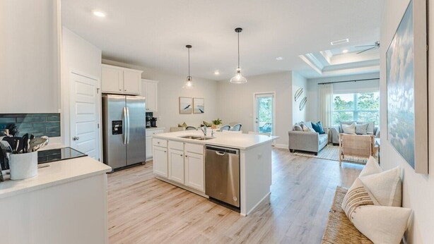 A modern kitchen with a central island, stainless steel appliances, and pendant lighting. - Low Rates WindMark| Golf Cart + Game Garage Retreat (Port St. Joe)