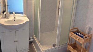 Un bagno con doccia, lavandino e specchio.
