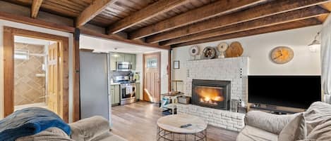 Una sala de estar acogedora con chimenea, televisor y sofá.