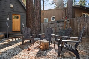 A wooden deck with Adirondack chairs and a fire pit. - Keep Tahoe Cozy - Pet friendly, walk to Lake & Ski (South Lake Tahoe)