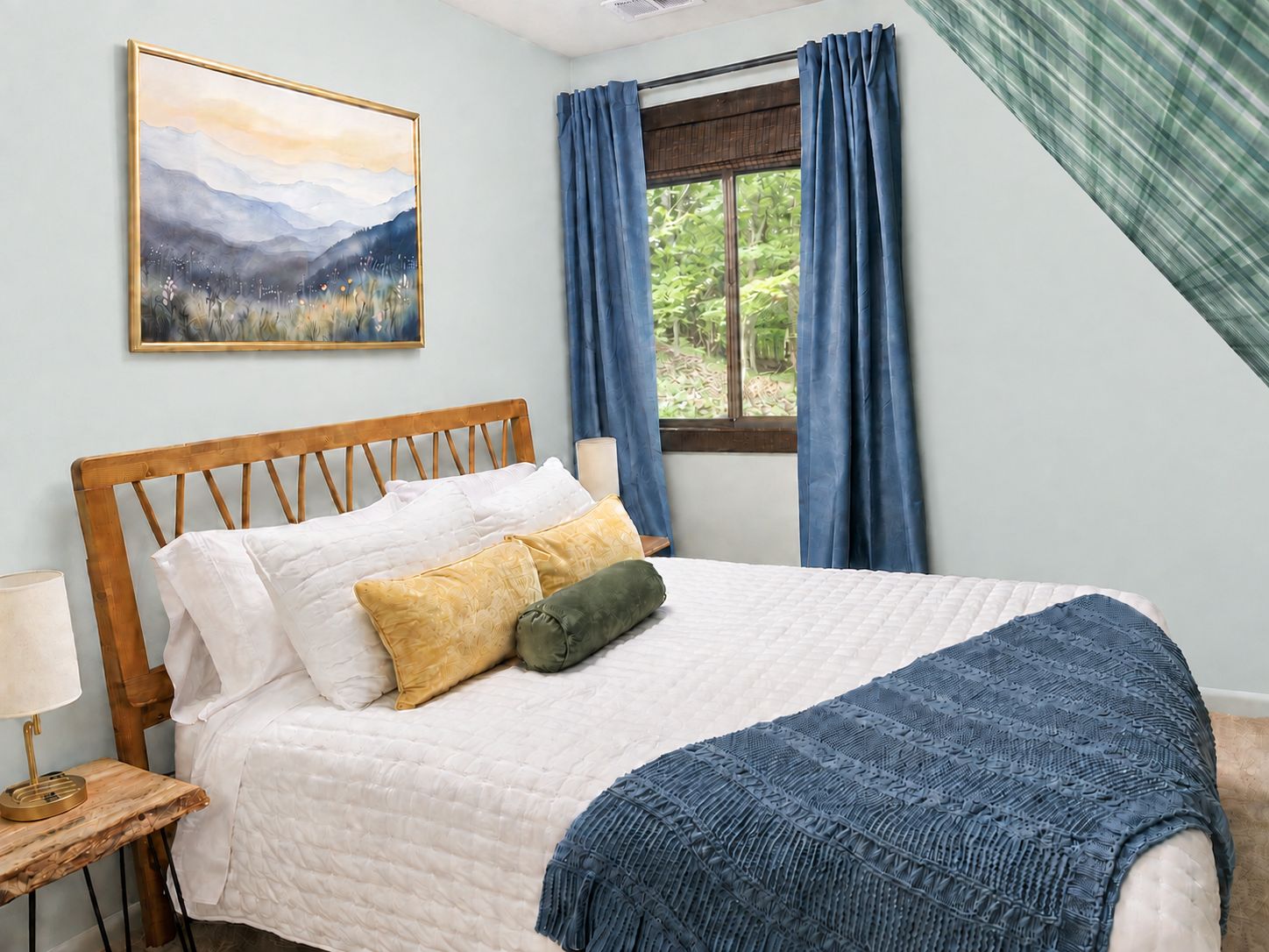 A bedroom with a wooden headboard, a bed with white and yellow pillows, a blue blanket, a bedside lamp, and a window with blue curtains.