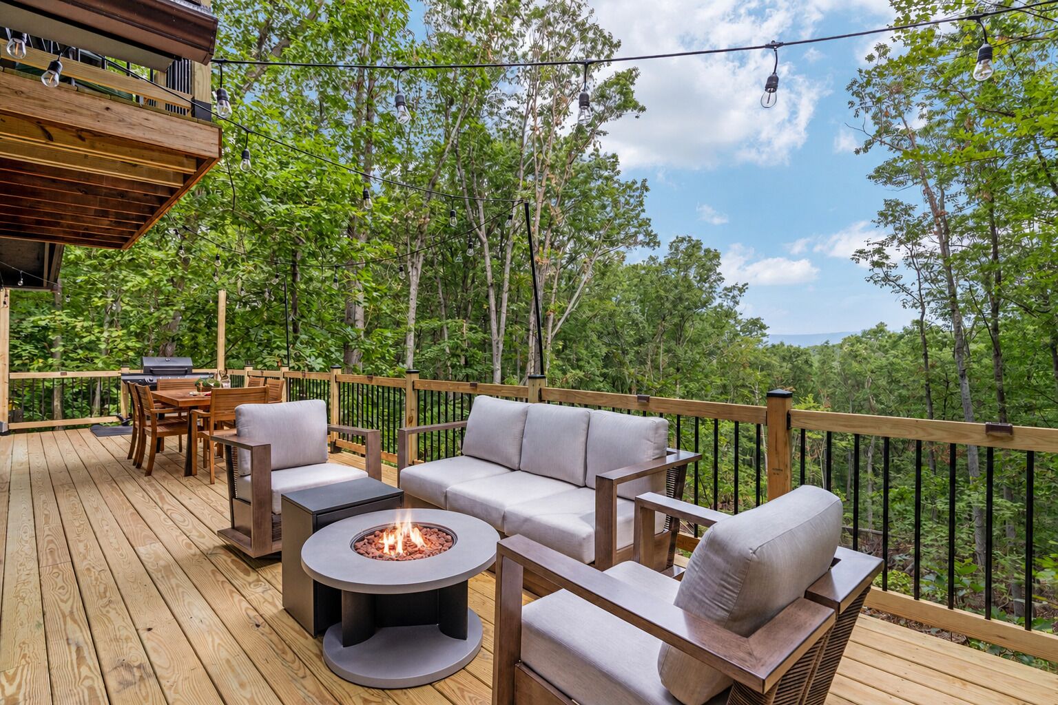 An outdoor deck with a fire pit, seating, and a grill.