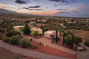 A residential area with houses, a paved driveway, and a clear sky. - Stunning Tuscany Style Home, Breathtaking 360 Views + Casita! (Cottonwood)