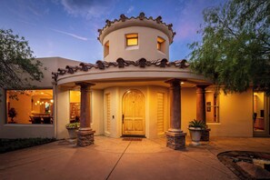 A building with a circular central section, a large arched entrance, and a small window above the door. - Stunning Tuscany Style Home, Breathtaking 360 Views + Casita! (Cottonwood)