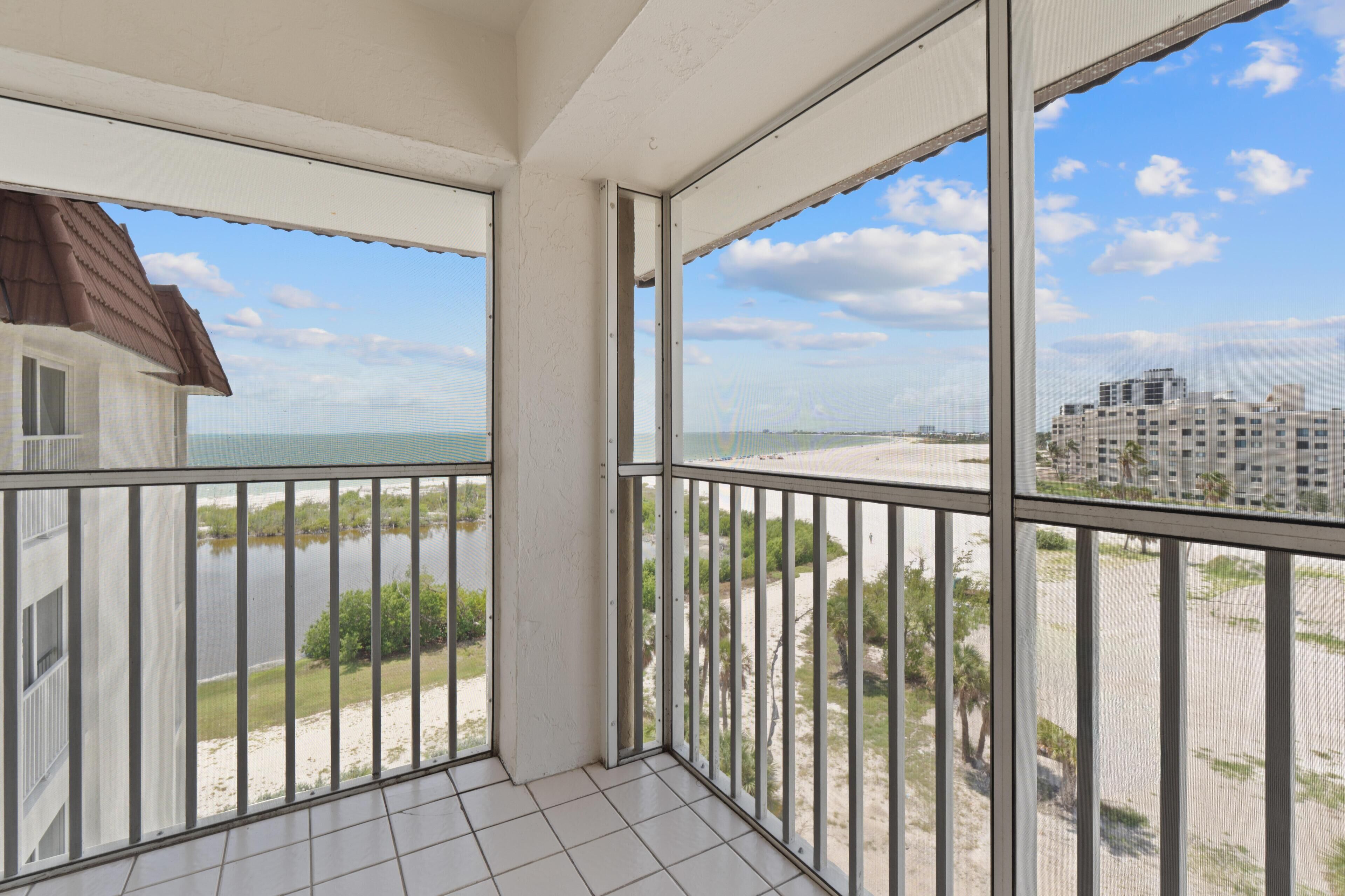 A balcony with a view of a beach and buildings.