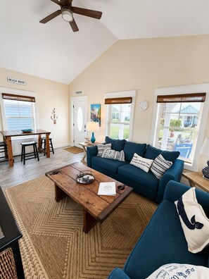 A living room with a blue sofa, wooden coffee table, and a ceiling fan.