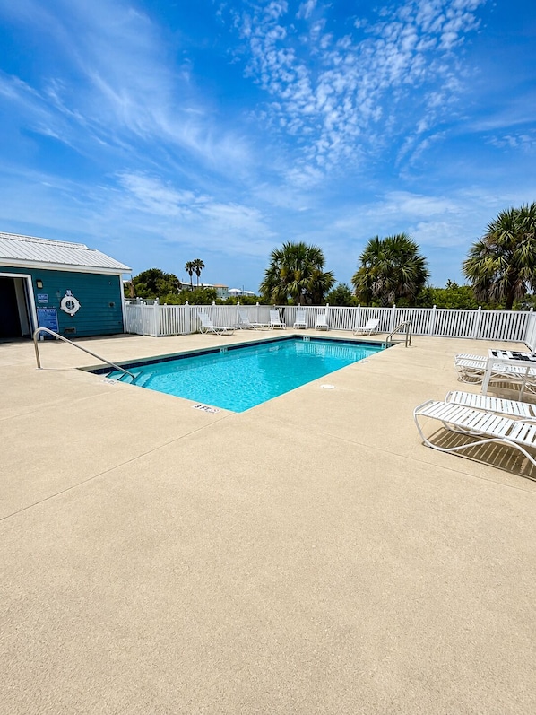 A swimming pool with lounge chairs and a lifeguard station.