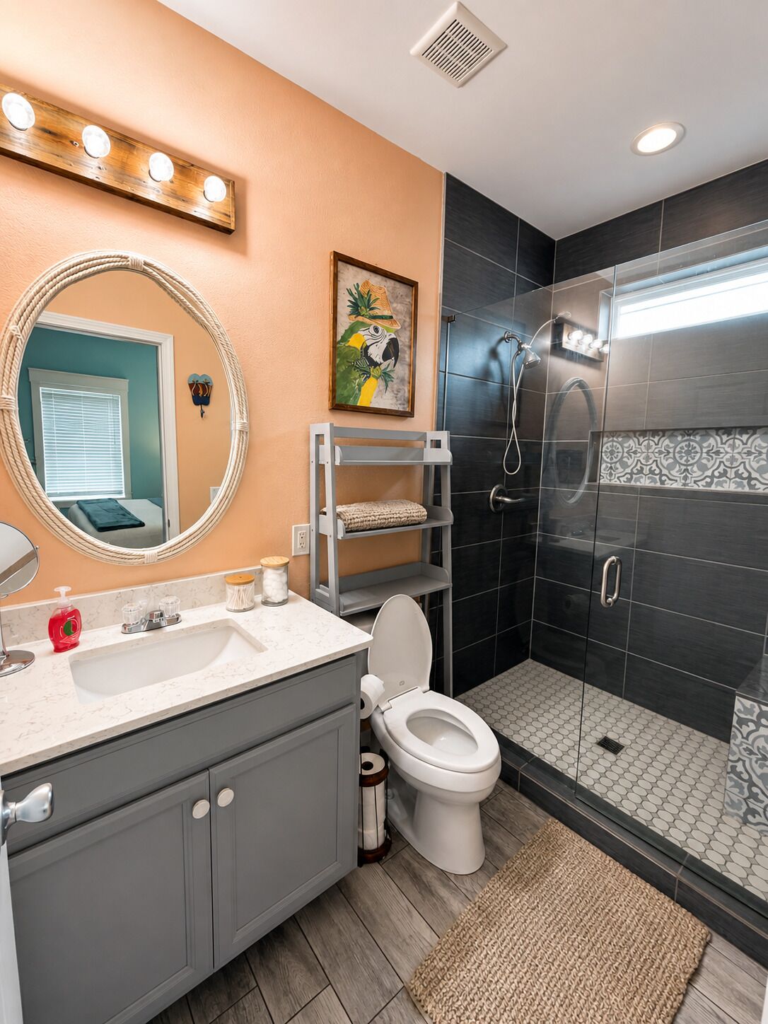 Une salle de bain comprenant un meuble-lavabo, des toilettes, une douche avec des portes en verre et un miroir avec éclairage intégré.