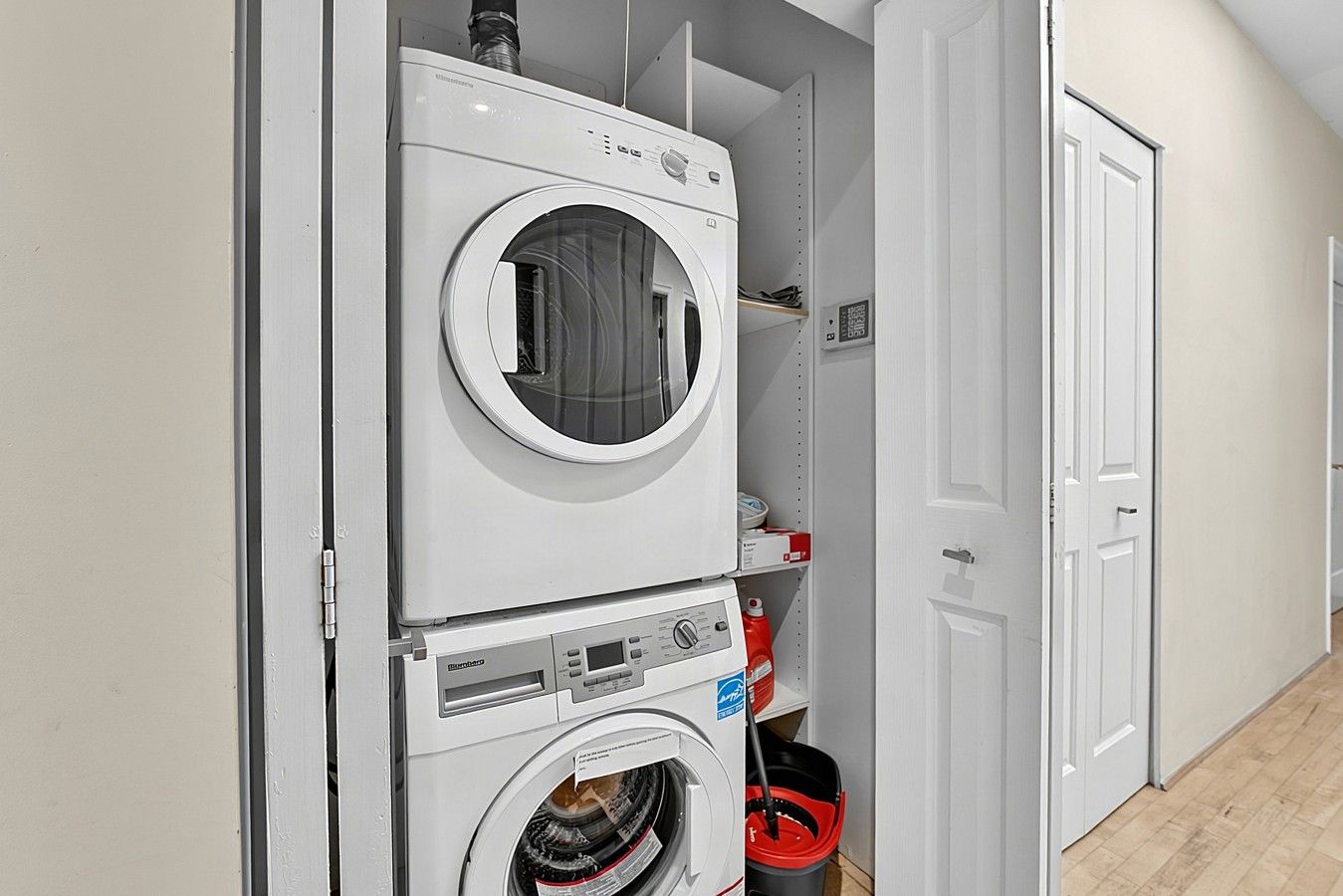 A laundry room with stacked washing machines and a dryer.
