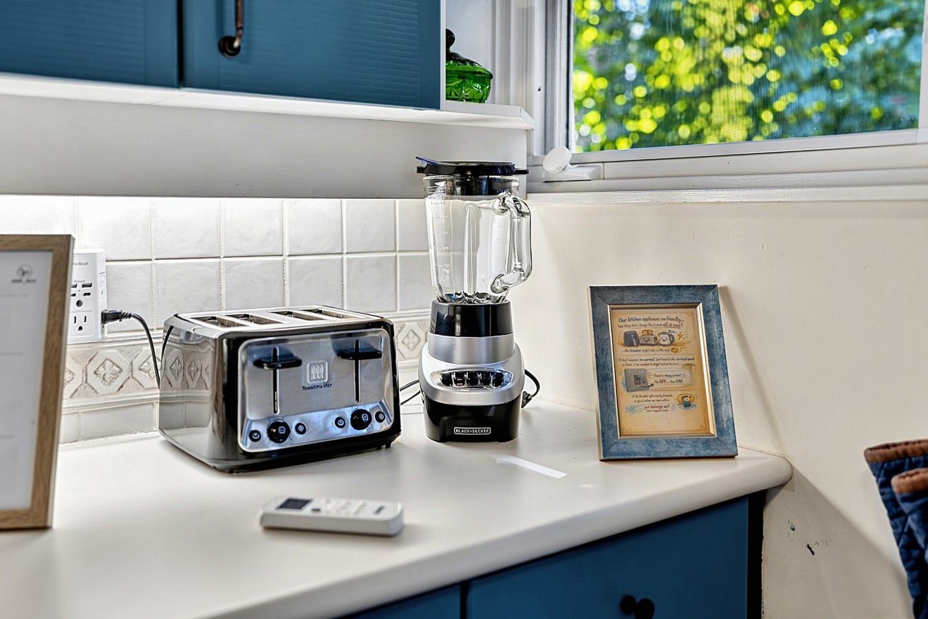 Eine Küchenarbeitsfläche mit einem Toaster, einem Mixer und einem gerahmten Zertifikat.