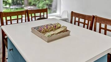 Une table à manger surmontée d’une boîte en bois contenant divers objets, entourée de chaises en bois.