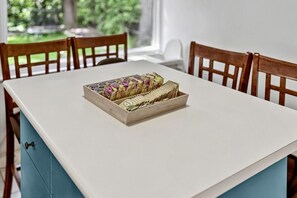 A dining table with a wooden box containing various items, surrounded by wooden chairs. - 2BR Upper private Suite | Near Grouse & Capilano (North Vancouver)