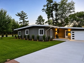 A modern single-story house with a garage, a well-maintained lawn, and a driveway.