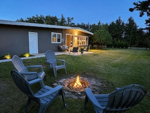 A house with a fire pit in the backyard, surrounded by outdoor furniture. - Mid-Century Modern Retreat Near Sand Valley and Lakes (Wisconsin Rapids)