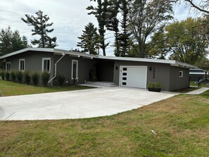 A modern two-story house with a garage, a covered driveway, and a well-maintained lawn.