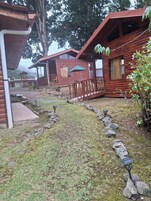 Uma fileira de cabanas de madeira com um caminho de pedra que leva a um gazebo.