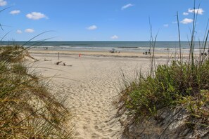 A sandy beach with dunes and sparse vegetation. - Ocean Gate I: Cozy Retreat Near Beach (St. Augustine)